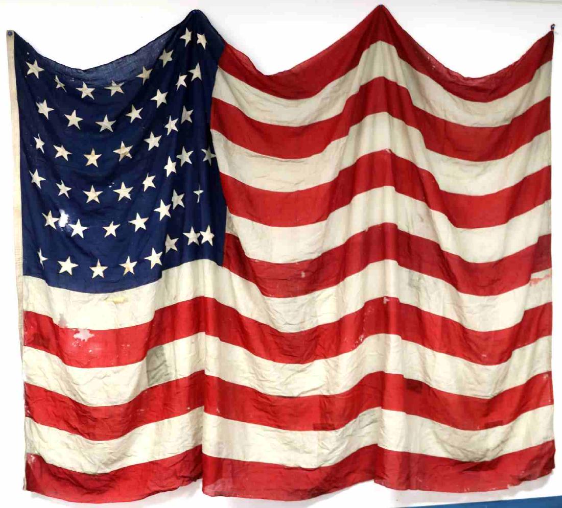 1908 46 STAR AMERICAN UNITED STATES FLAG VERY WORN: Stars sewn to both sides, holes, rips and stains present. Measures about 12 by 8 feet. Poor to fair condition.