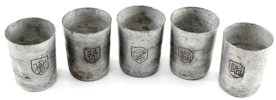 WWII GERMAN THIRD REICH ALUMINUM WAFFEN SS CUP LOT: Lot of five aluminum schnapps cups, each with a different Waffen-SS mark. One each has the crest of the LSSAH division, Das Reich Division, Wiking Division, Estonian SS, and SS runes. In very good con