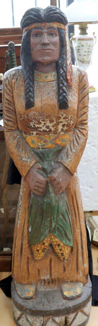 VINTAGE 54 IN TALL CORN MAIDEN CIGAR STORE INDIAN: Vintage wooden 54 inch tall corn maiden store Indian. Displays some paint wear, as well as some signs of cracks which have been glued. Appears to be signed "MDB" on the base. Fair condition. Local pic