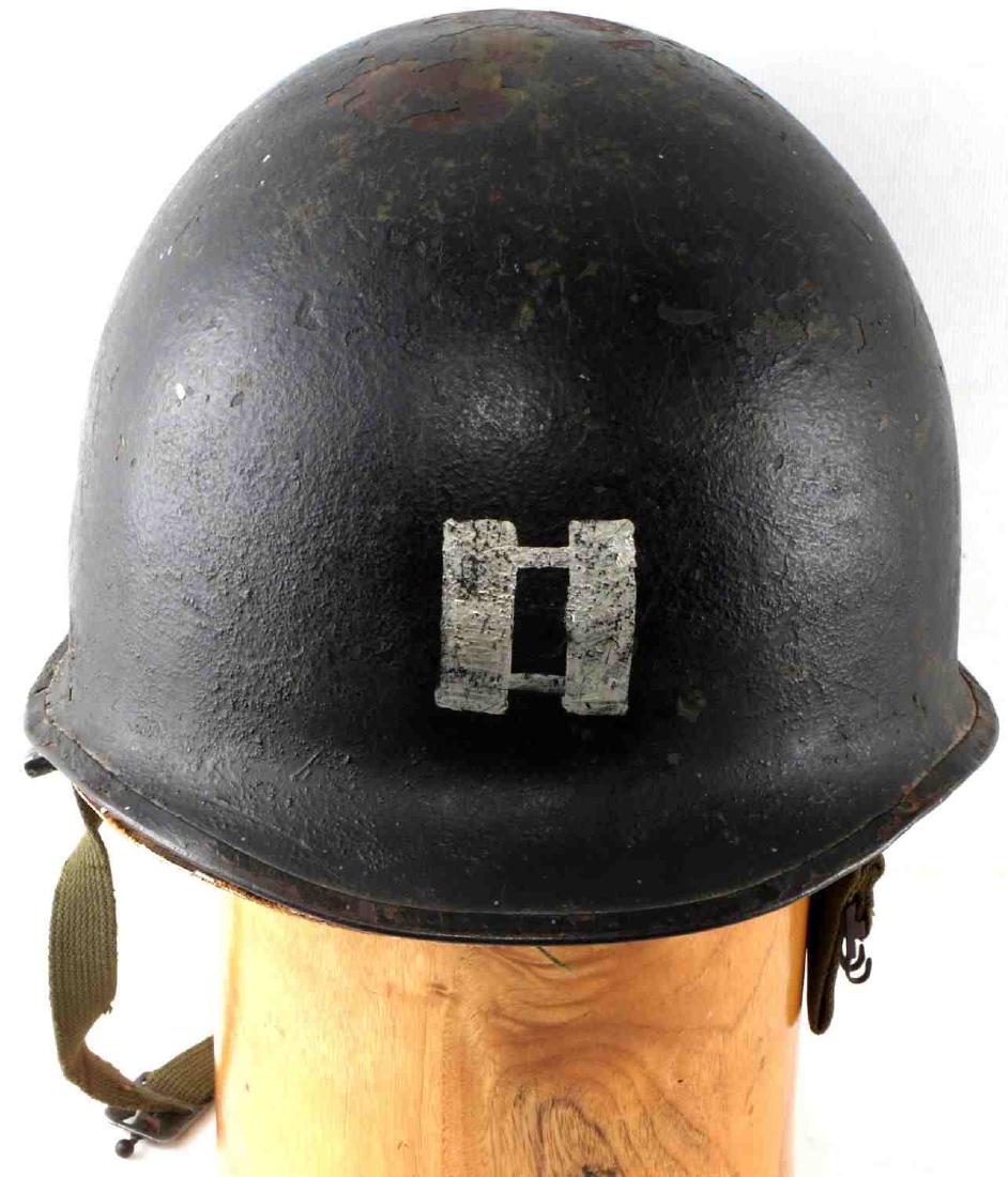 WWII 1ST INFANTRY DIVISION STENCIL HELMET CAPTAIN: US Military helmet with captain rank to front, shield with "1" to center at left ear, golden flaming grenade to right ear and red paint to back with "Rickenbauer" written. Interior is painted red, let