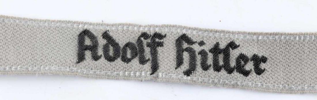 WWII GERMAN SS LEIBSTANDARTE HITLER CUFF TITLE: Rare German Leibstandarte SS Adolf Hitler cuff title. Silver bullion wire piping with embroidered "Adolf Hitler" on front. Very good condition with only some slight fading and very small stains presen