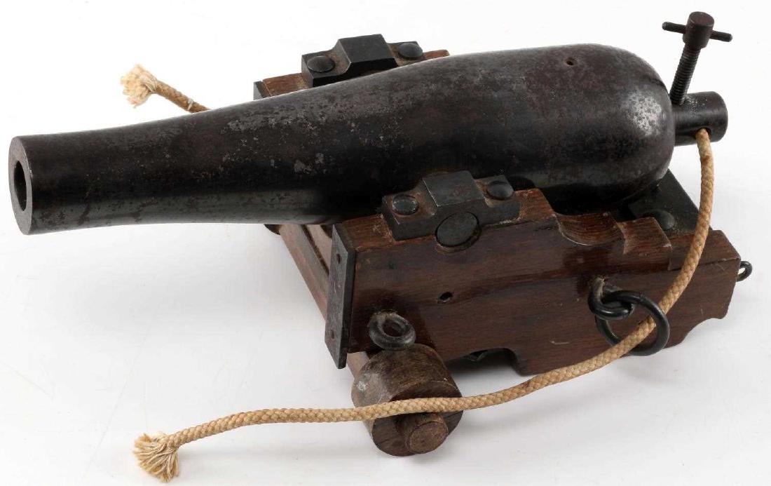 DECORATIVE 1860S NAVAL CANNON DESK TOP MODEL: Decorative cast of an 1860s Naval cannon with adjustable elevation. Measures 7 by 10.75 by 4 inches, weighs 7.6 pounds. Missing back wheels but overall in good condition.