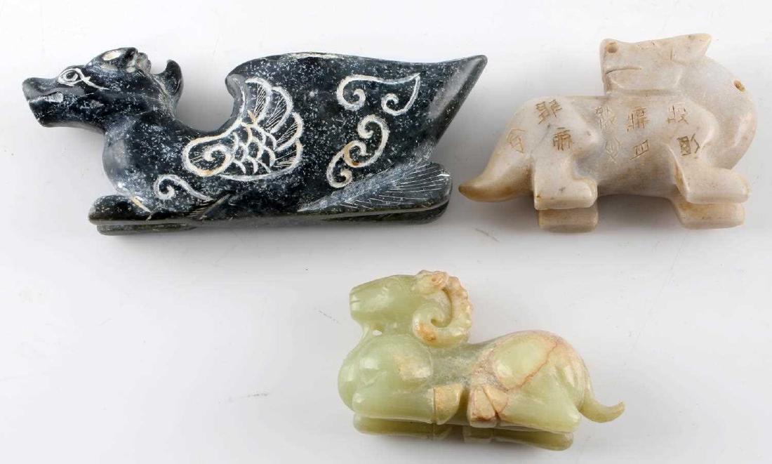 LOT OF THREE CHINESE JADE CARVED FIGURES DRAGON: One green jade carved auspicious ram figure measuring 3.25 inches by 1.25 inches by 1.5 inches. Solid light gray jade carving, possibly of dog, incised throughout with Chinese characters. Measures 3.5