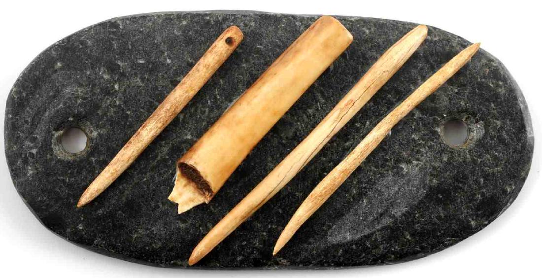 HARD STONE GORGET WITH WOODLAND ERA BONES: Measures 5.5 by 2.75 inches. Bones are glued to stone. Gorget has two holes. Very good condition.