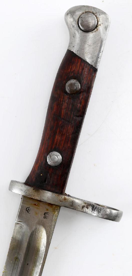 14253JAPANESE TYPE 30 ARISAKA BAYONET IN SCABBARD: Japanese Type 30 Arisaka Bayonet In Scabbard. Blade measures 10 inches long, 14 3/4 inches long overall. Has altered makers marks including a set of overlapping circles, and a star in shield insignia.