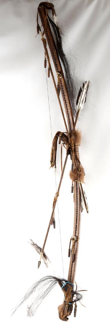NATIVE AMERICAN MODERN HAND CRAFTED BOW AND ARROW: Well made bow, wrapped in synthetic material, with leather accents, horse hair and bird feathers. Bow measures 60 inches long (not on the curve). Arrow is wooden with feathers at end and metal tip is
