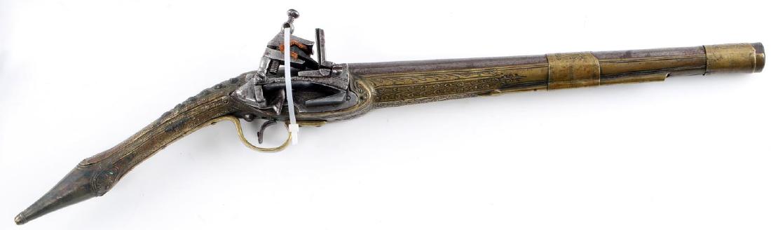 19TH CENTURY MIDDLE EASTERN FLINTLOCK PISTOL: Ornate 19th century Middle Eastern (possibly Turkish) flintlock. 12" smooth bore barrel with brass inlay design. High detailed engraved brass handle with relief pebble-like grip. Very good overall.