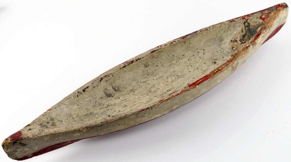 VINTAGE HAND CARVED WOODEN CANOE BOAT MODEL: Wooden canoe measures 20 inches long and 4.75 inches wide. Needs a stand to prop up correctly. Paint loss and wear. Fair to good condition.
