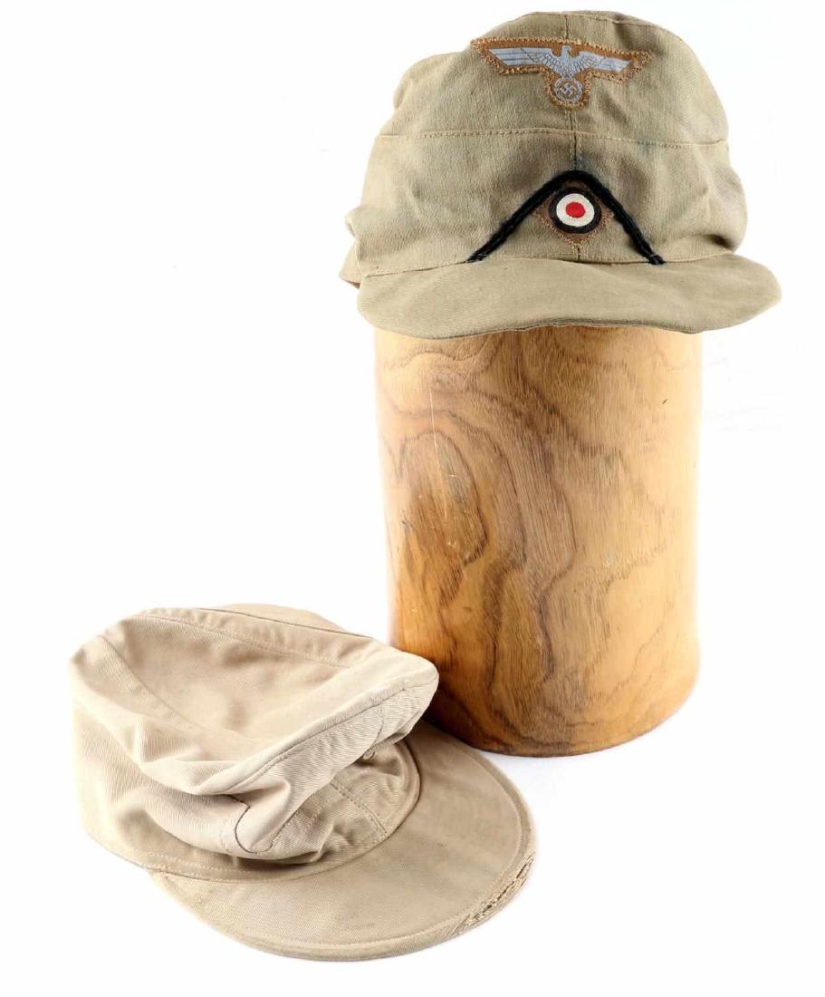 WWII GERMAN REPRODUCTION M43 FIELD CAP LOT OF 2: Quality reproduction German M43 field caps. 1 cap has Reichsadler and cockade patches and is interior stamped. Good condition overall. Some stains and wear present. Stitching loose in 1 section on 1 c