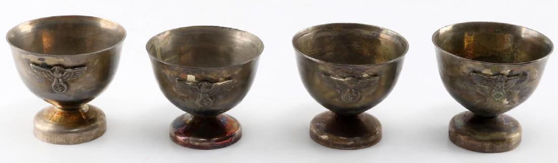 WWII GERMAN SET OF 4 SCHNAPPS CUPS NSDAP BRONZE: Set of Third Reich brass schnapps cups or egg stands. Reichsadler in relief to front on each. Measures just under 2 inches tall. Very good condition. Unauthenticated, sold as is. This lot has a reserv
