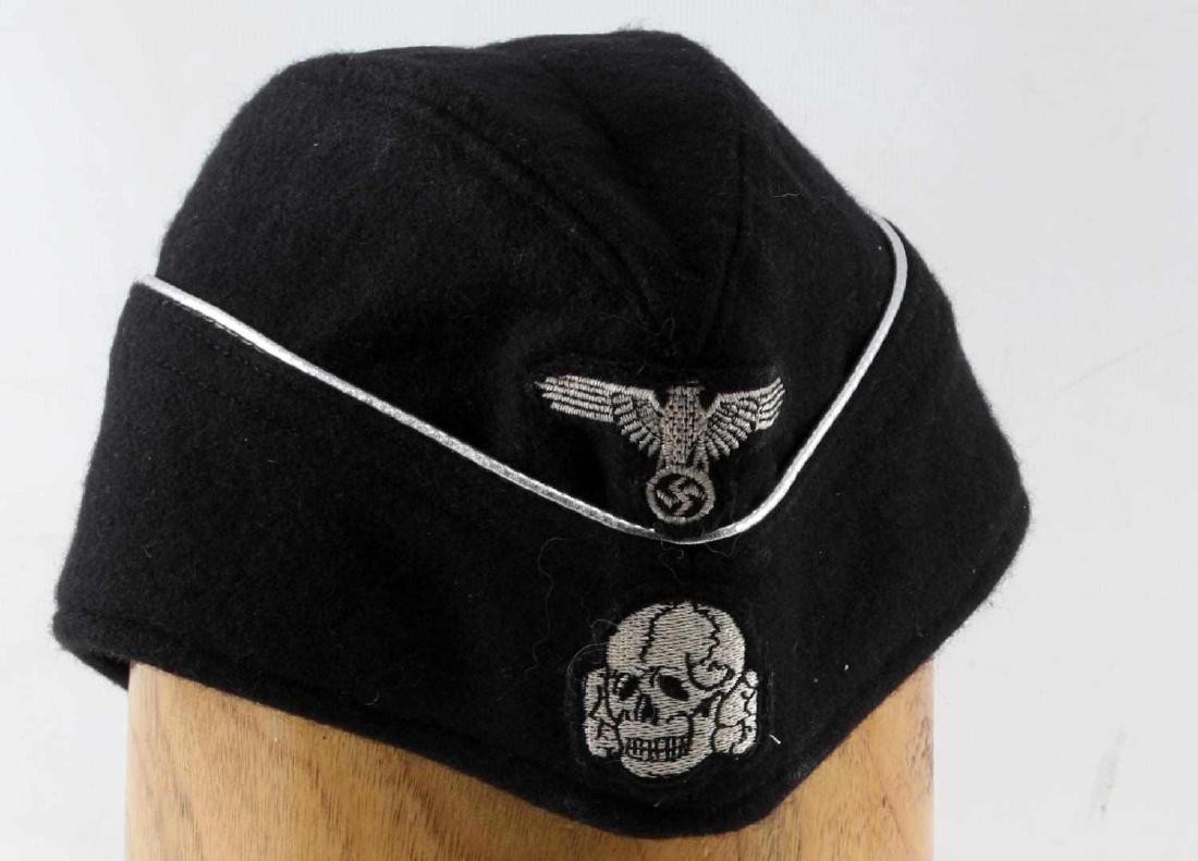 WWII GERMAN SS PANZER OVERSEAS CAP: WWII German SS Panzer officer's overseas cap. Sewn Totenkopf and Reichsadler patches at its front with silver piping. Near excellent condition. Size small. Unauthenticated. Sold "as is". This lot has 
