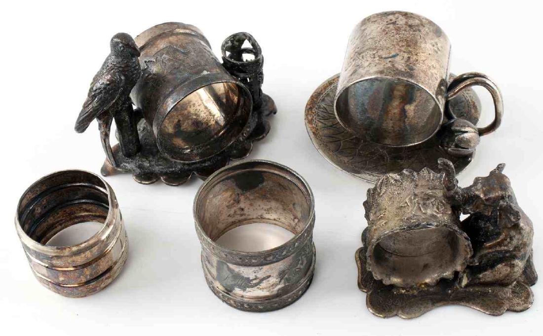 LOT 5 ANTIQUE SILVER PLATE DECORATIVE NAPKIN RINGS: Five Victorian silver plate ornate napkin rings. One with incised decoration and name "Hattie" One with incised river boat scene and initials "JMS" One with seated elephant against ring. Marked "Silve