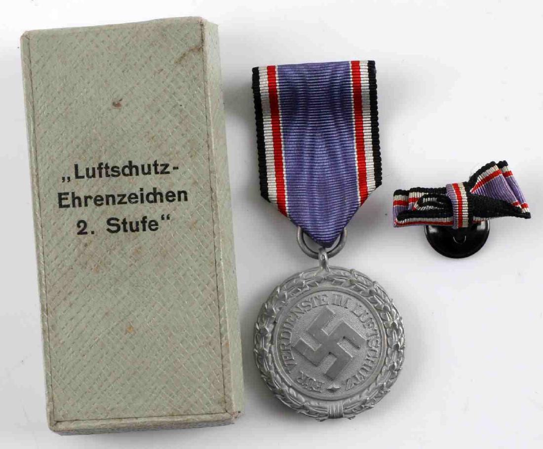 WWII GERMAN THIRD REICH AIR RAID PROTECTION MEDAL: German Air Raid Protection Medal, 2nd Class in box and with lapel device. Medal is unmarked. Medal and issue box show almost no wear/age and medal is complete with suspension ring and correct ribbon. 
