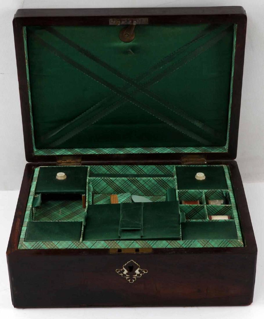 SMALL WOOD VINTAGE SEWING KIT IN WOODEN CHEST: Chest is dark wood and has a mother of pearl inlaid design on lid. Inside is lined is plain and patterned green fabric. Inside of lid envelope type of compartment. Bottom has compartmentalized section