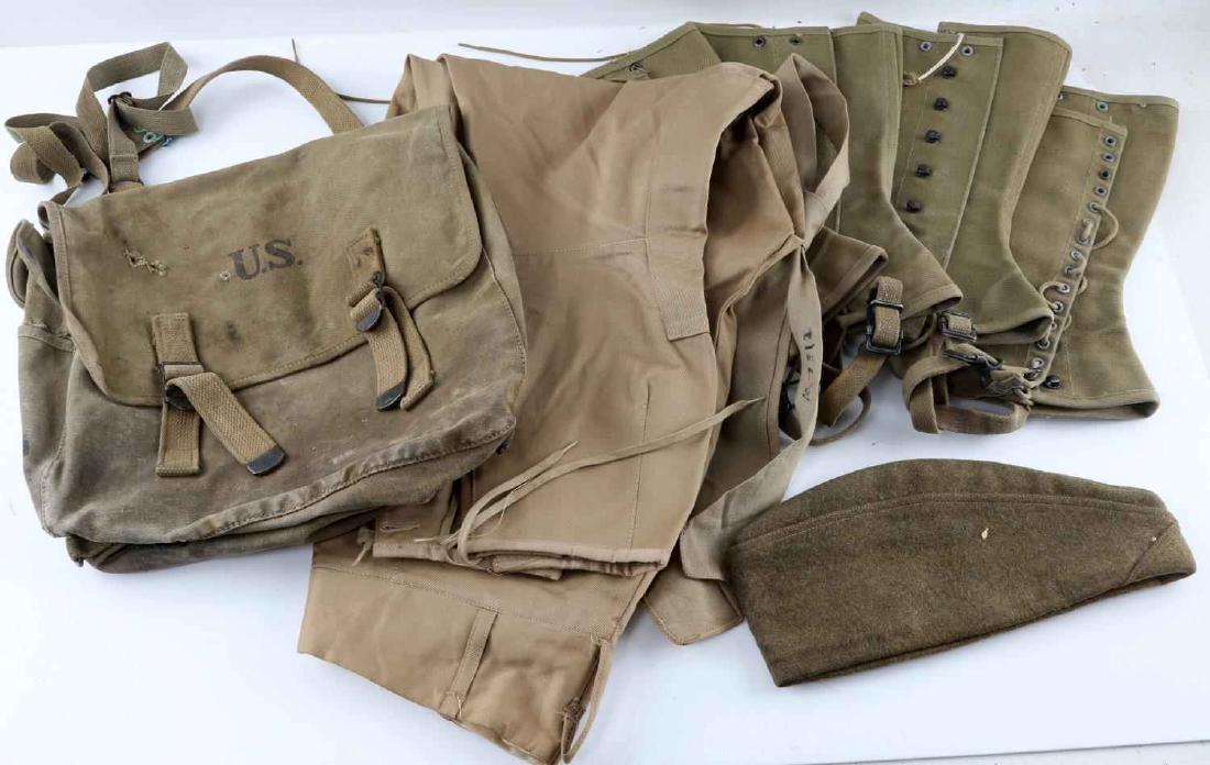 WWI & WWII US ARMY CLOTHING & GEAR LOT OF 6: This lot includes 2 pairs of WWI doughboy spats, 1 WWI garrison cap, 1 pair of WWII Army cavalry breeches, 1 WWII service tie, and 1 WWII musette bag. Items vary in condition with most being in good s