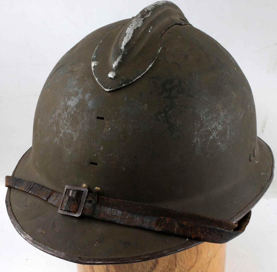 WWII FRENCH M26 ADRIAN STEEL COMBAT HELMET: French M26 Adrian helmet. Does not have a front badge plate. Six finger imitation leather liner. In very good condition overall. Minor paint wear along the crest and some on the body. Minor denting. C