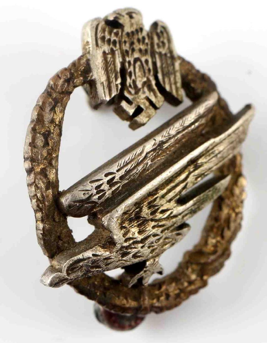 WWII GERMAN MINIATURE PARATROOPER ARMY BADGE: Miniature (1.75" diameter) German Heer Fallschirmjager badge. 2 piece construction. Reverse marked with what appears to read "GLKWA ERG". Reverse attaching pins are broken and in need of repair. Good 