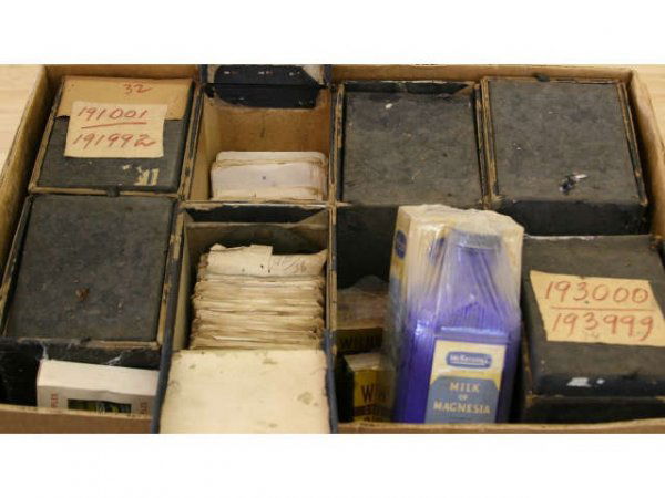 ANTIQUE APOTHECARY VINTAGE PRESCRPTIONS: Box full of old vintage prescription write ups, also containing a few antique apothecary glass bottles of Red Arrow Milk of Magnesia, Wildroot Coconut Oil Shampoo, St. Joseph's Pinetar and Honey Compo