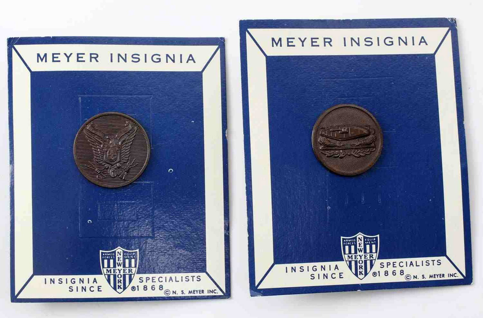 WWI US ARMY COLLAR ENLISTED MAN COLLAR DISC LOT: Pair of collar discs both from the early 20th century and both mounted on cardboard NS Meyer cardboard backing. One is an AEF Tanker collar disc, while the other is a Philippine Constabulary disc. Bot