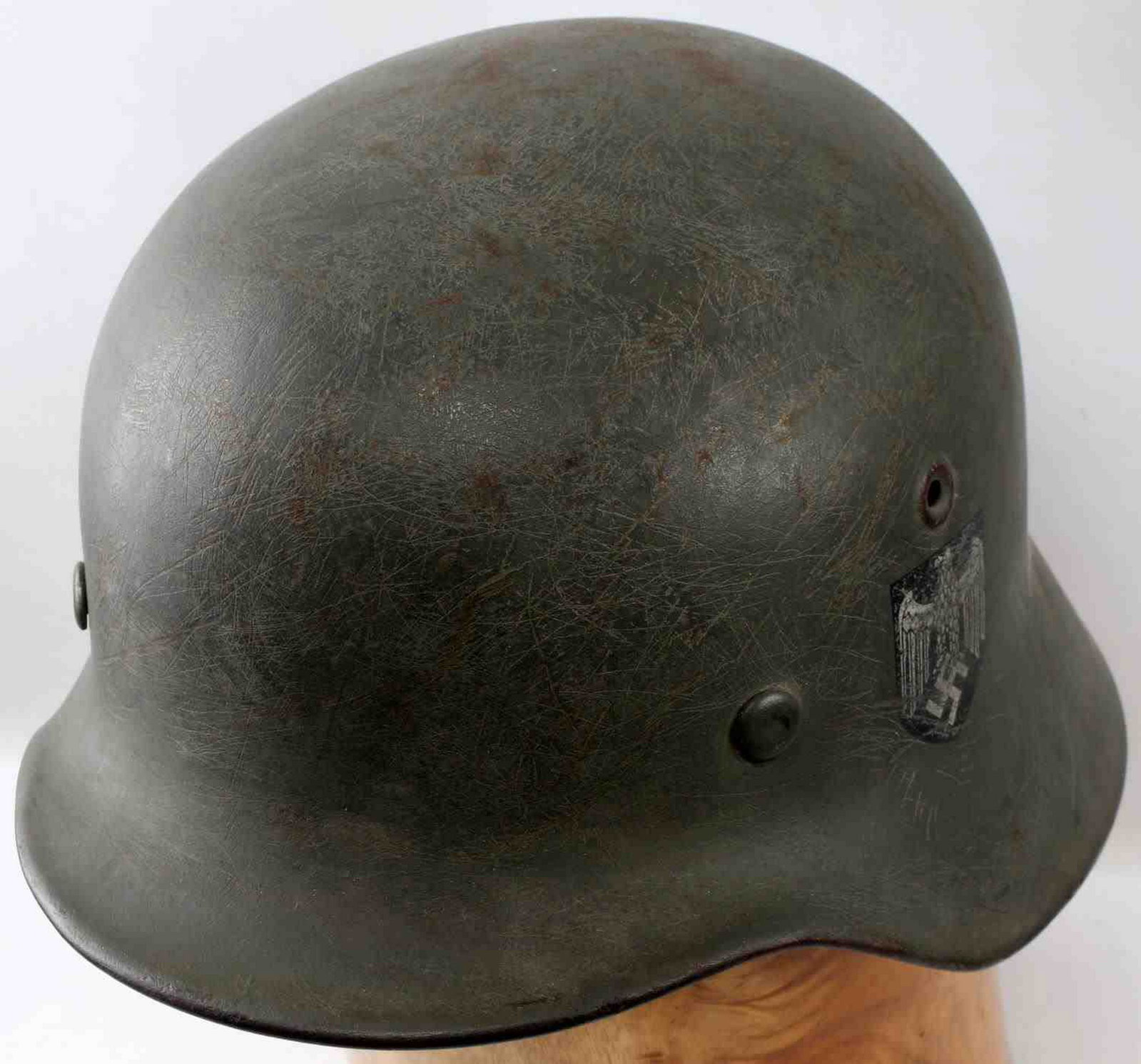 WWII GERMAN THIRD REICH HEER M 40 COMBAT HELMET: German double decal Heer combat helmet. M40 version with rolled edges and stamped vent holes. Has Heer eagle decal at left side and national tri-color shield at the other. Maker marked "EF62" and "137