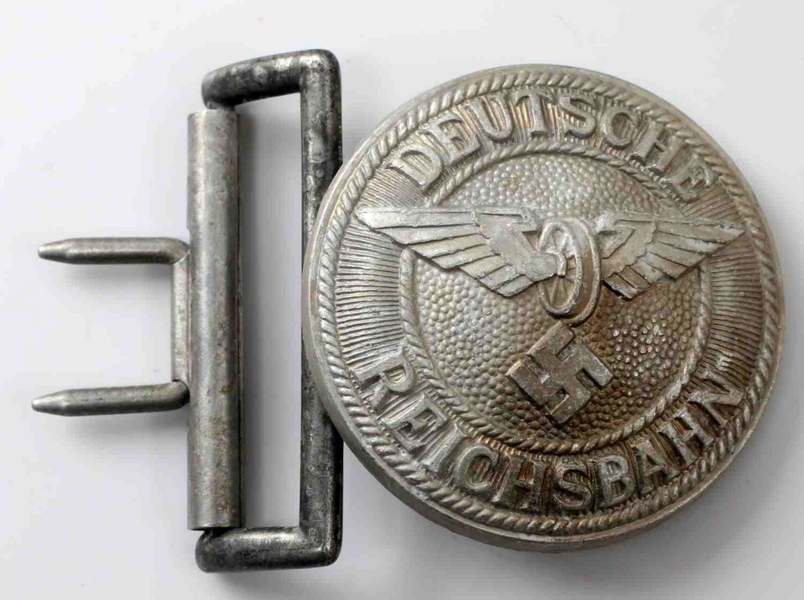 WWII GERMAN RAILWAY REICHSBAHN OFFICER BELT BUCKLE: German Reichsbahn officer's belt buckle. Two piece stamped aluminum construction. Includes 1 belt keeper. Reverse marked with stylized A for Assman and "DRGM 43." Very good with some patina and corros