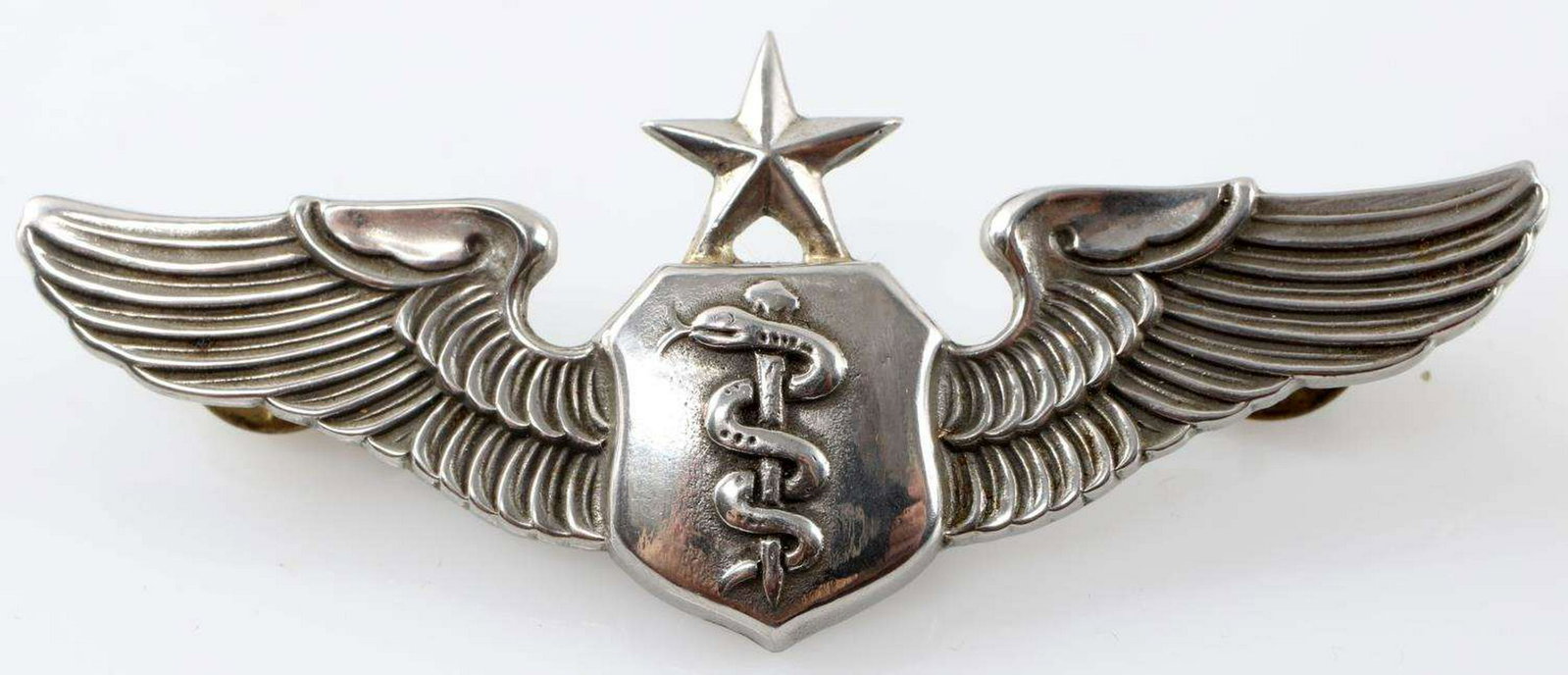 US KOREAN WAR ERA SENIOR FLIGHT NURSE WING BADGE: Senior Flight Nurse wing badge. No maker mark and in good condition. Some wear and slight detail loss present. Measures just over 3 inches long.