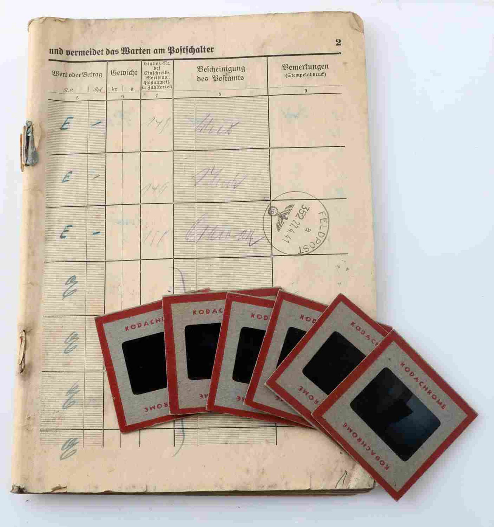 WWII GERMAN FELDPOST DOCUMENTS & PHOTO SLIDE LOT: This lot includes 1 German Feldpost ledger with hand written notes and NSDAP Feldpost stamps. Cover is missing from ledger and some foxing is also present. Lot also includes 6 American early color sli