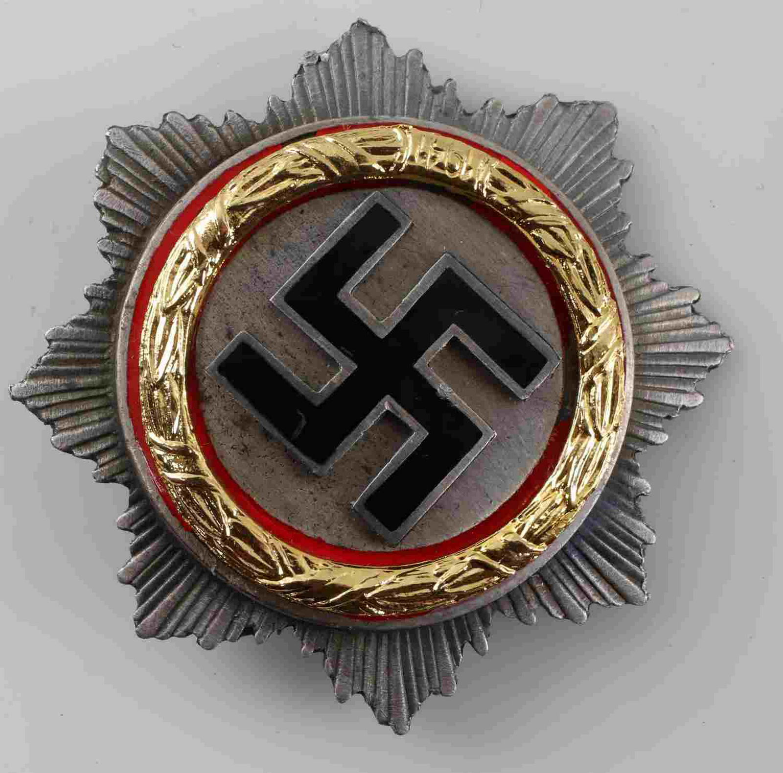 WWII THIRD REICH GERMAN CROSS IN GOLD: Deutsches Kreuz in gold. Reverse maker marked with what appears to read "G Brehmer Mark Meukirch." Thin vertical pin back. Some enamel wear and patina present. Good overall. Unauthenticated; sold as i