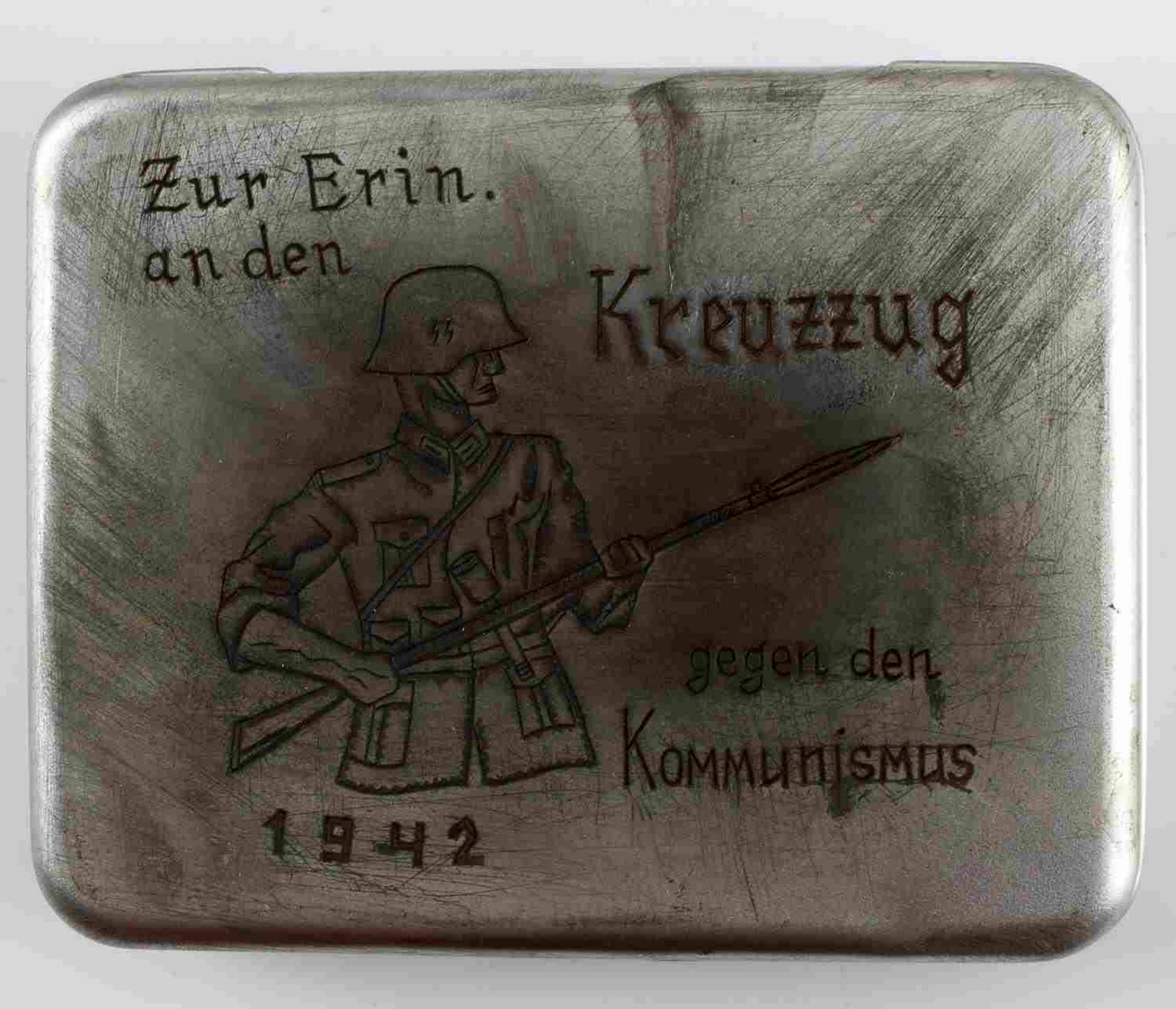 WWII GERMAN 3RD REICH ANTICOMMUNIST CIGARETTE CASE: Trench art cigarette case with a design showing an SS trooper with K98 and bayonet with 1942 underneath and anti-Communist slogans. In very good condition. Unauthenticated/Sold 'as is'. This lot has a
