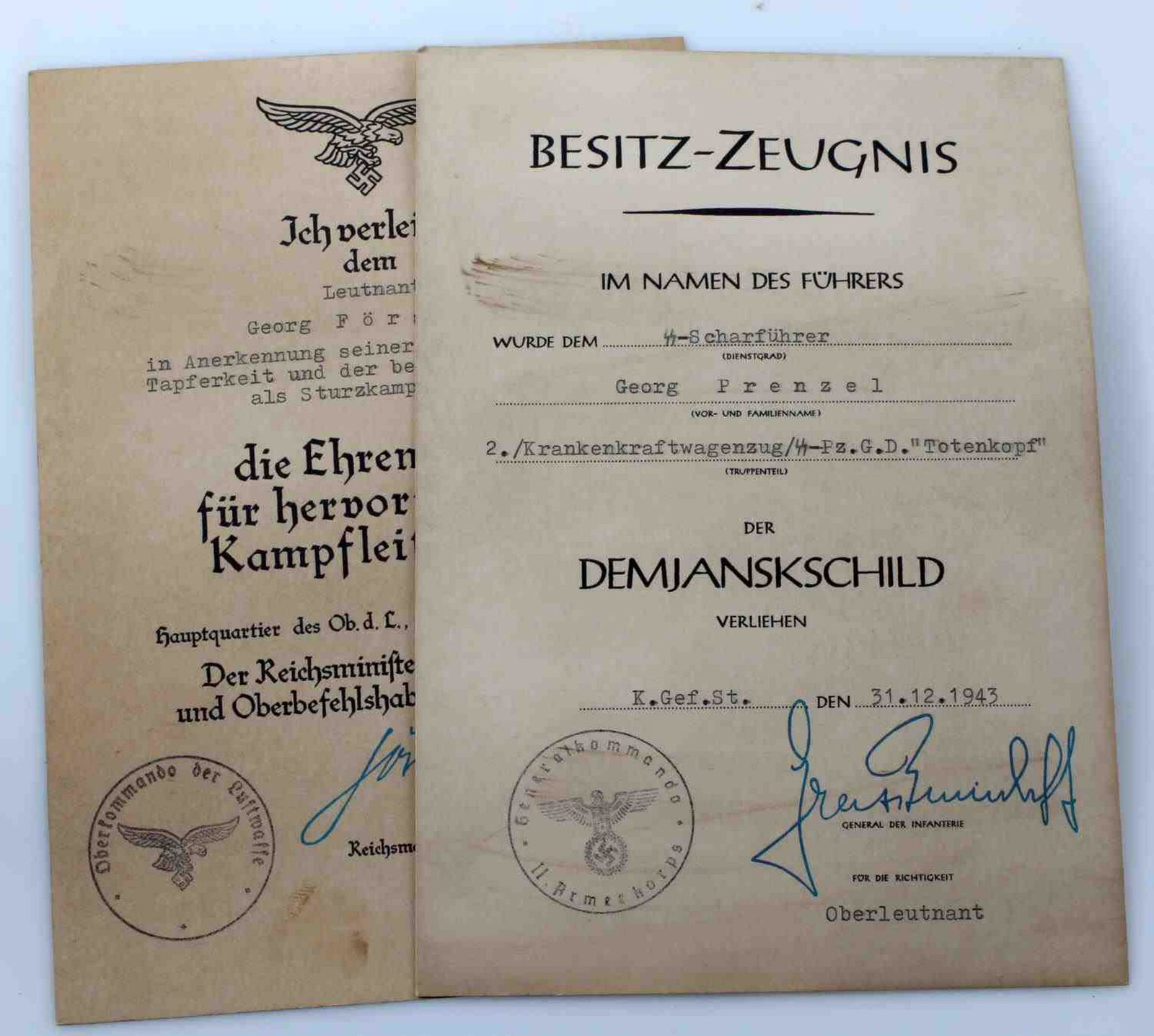 WWII GERMAN THIRD REICH AWARD CITATION LOT OF 2: Lot includes 1 German Luftwaffe Honor Plate award citation and 1 SS Demyansk shield award citation. Both facsimile signed by NSDAP officials including Hermann Goering. Very good overall with some slig