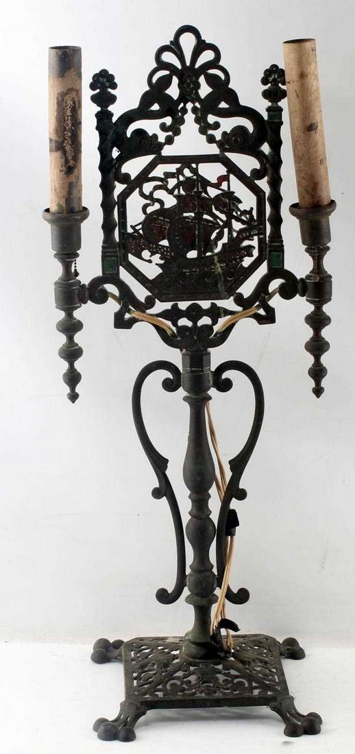 ANTIQUE FRIGATE SHIP DOUBLE SCONCE IRON LAMP: Open work design with frigate ship to center and a holder to each side. Stands 25 inches tall. Good antique condition.