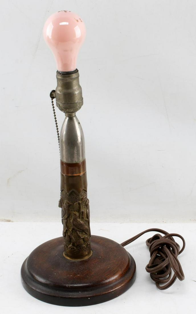 WWII US MILITARY TRENCH ART 40MM ROUND LAMP: Trench art lamp made from a 40mm round. Has a design with several bird decorated around the body. Wooden base. Pull chain. Lamp has not been tested. No lampshade.