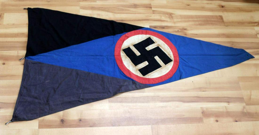 WWII GERMAN THIRD REICH HITLER YOUTH PENNANT FLAG: Black and blue pennant flag believed to be for a Hitler Youth unit. Measures approximately 31x56 inches. Has swastika roundel on one side and single sig rune on the other. Has a 4 inch long tear which