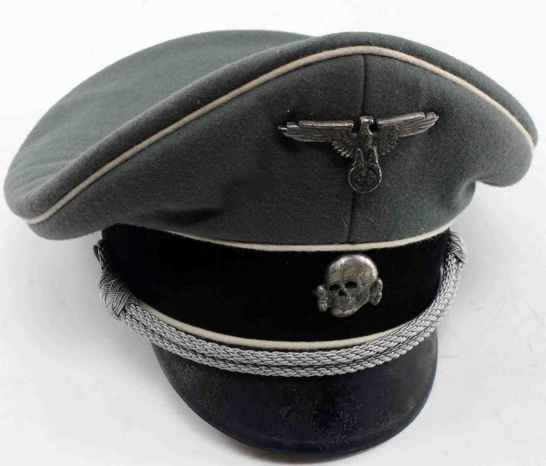 WWII GERMAN THIRD REICH SS OFFICER VISOR CAP: German SS Infantry Officer Visor Cap. Green wool with a black band and white piping. Silver bullion wire chin strap with leather sweat band. Black vulcan visor shows some wear and sun damage. Yellow s