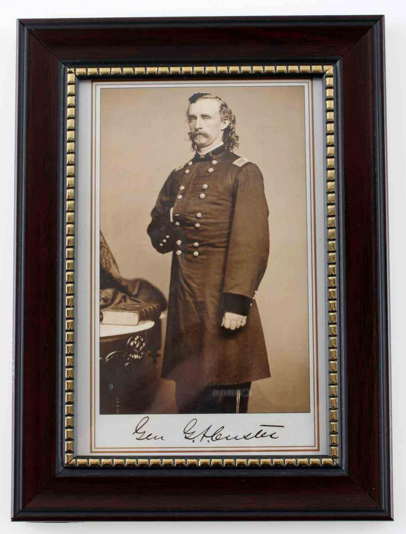 GEORGE CUSTER PHOTO CARD REPRINT SIGNED FACSIMILE: Framed reprint of a signed photo of General George A Custer, including a facsimile of his signature. The photo itself measures 4x5 7/8 inches, while the frame measures 5 9/16x7 9/16 inches.