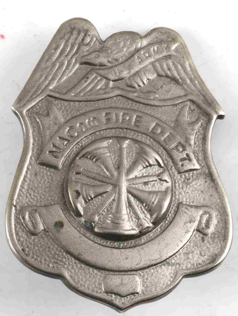US ARMY OBSOLETE NACOM FIRE DEPARTMENT BADGE: Obsolete US Army NACom FIRE DEPT Fireman’s Badge. Measures 1 7/8” wide by 2 9/16” tall. The front reads ‘’US Army NACom FIRE DEPT’. This is an eagle top badge with a shield below and trump
