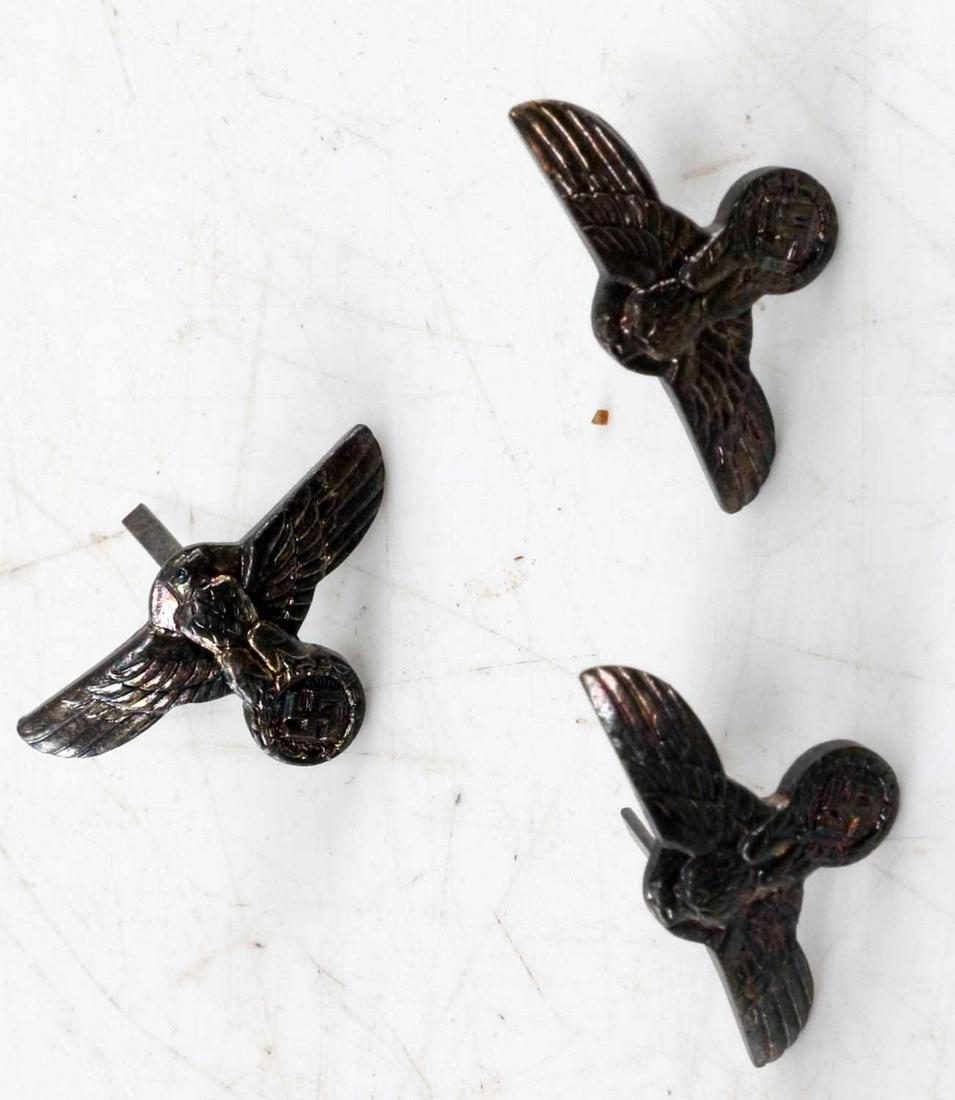 WWII GERMAN THIRD REICH SS DAGGER HANDLE EAGLE LOT: Lot contains three Reichsadler badges for the handles of SS daggers. Each measures 1 inch wide by 9/16 of an inch high. Reverse is maker marked 'RZM M1/6'. Two flat vertical prongs on the reverse. Nic