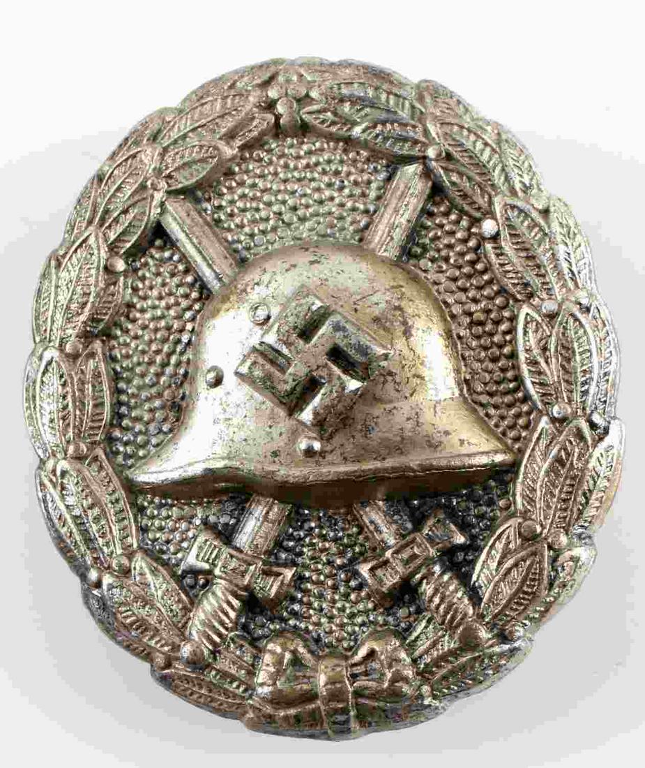 WWII GERMAN SPANISH CONDOR LEGION WOUND BADGE: Helmet with swastika to center, crossed swords behind and oak leaf surrounding. Vertical pin back. Nickel construction. Measures 1.75 inches long. Unauthenticated, sold as is.