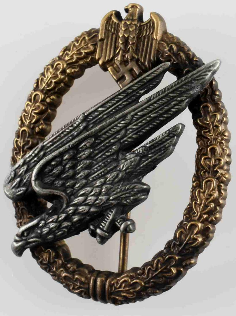 WWII 3RD REICH GERMAN ARMY PARATROOPER JUMP BADGE: Diving eagle in silver and top eagle and wreath in gold. Thin vertical pin back. C E Junker Berlin SW marked to back. Very good condition. Unauthenticated, sold as is.