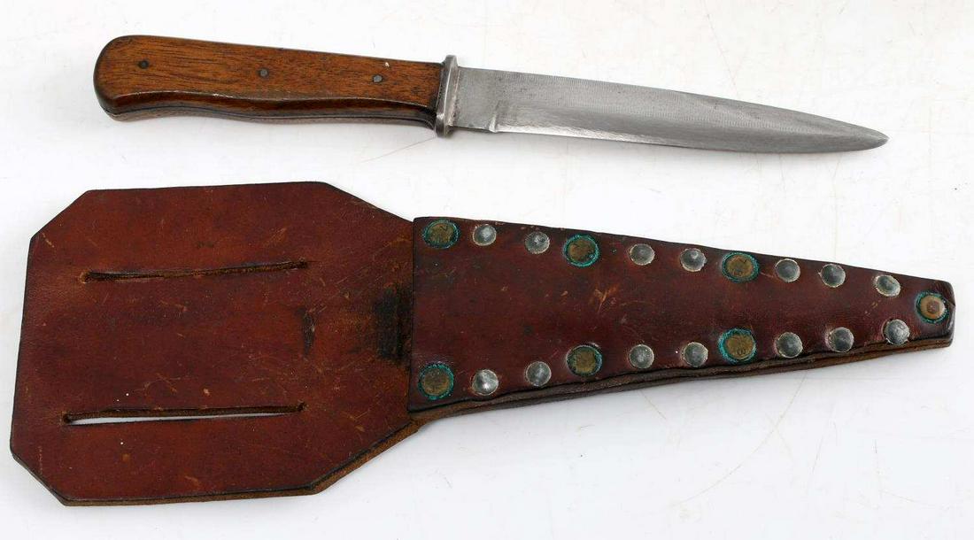 WWI NAHKAMPFMESSER GERMAN TRENCH BOOT KNIFE: German trench knife / boot knife with theater made flapper scabbard. Blade measures 5 3/8 inches long. Wooden grip. Triangular shaped leather sheath with metal rivets. Sheath measures 11 X 4 inches. V