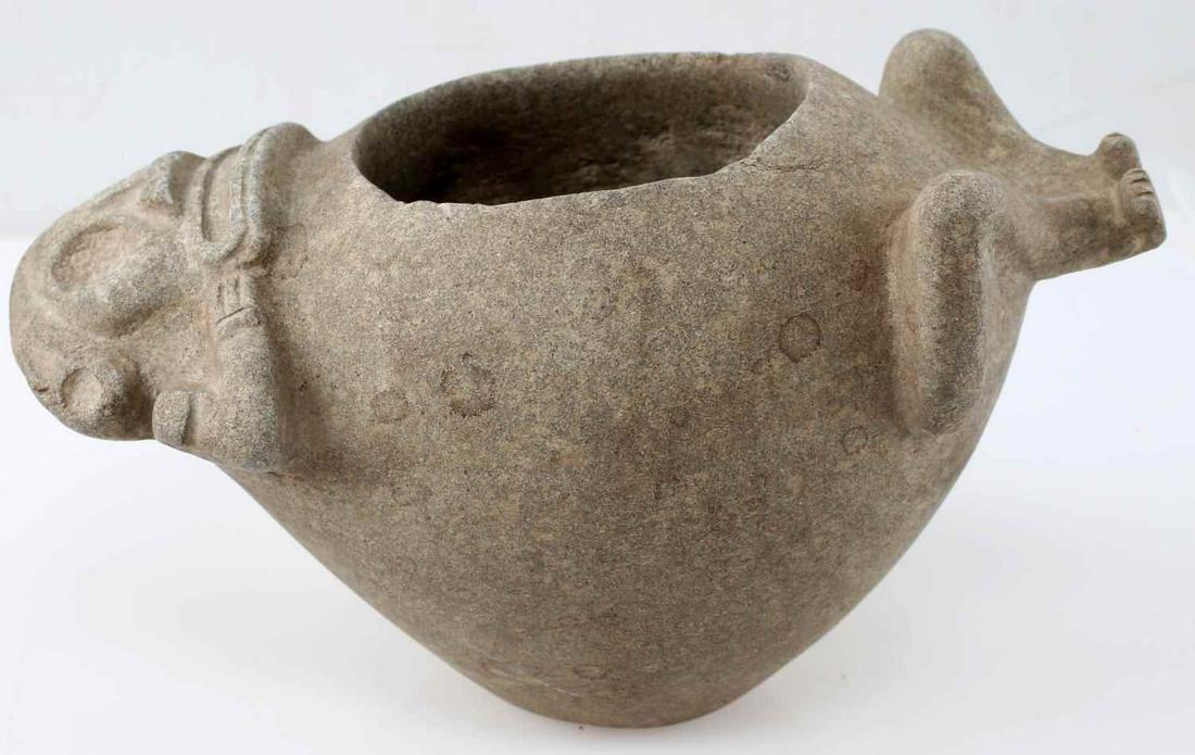 TAINO COHOBA BOWL W/ ANTHROPIC RECLINING GOD: Taino Cohoba bowl featuring a reclining god or ancestor. Nicely detailed face with residual hand touching sides of mount. Legs and feet complete the back of figure. Made of andesite and measures 5 1/2
