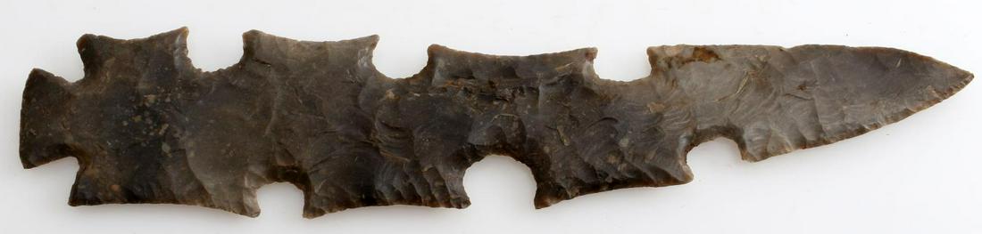 GREY CHERT ECCENTRIC ARROWHEAD POINT LOUISIANA: Somewhat curved eccentric point from Central Louisiana collection believed Texas provenance. Broad flaking with some edge work. Ground base. Measures 8 inches long._