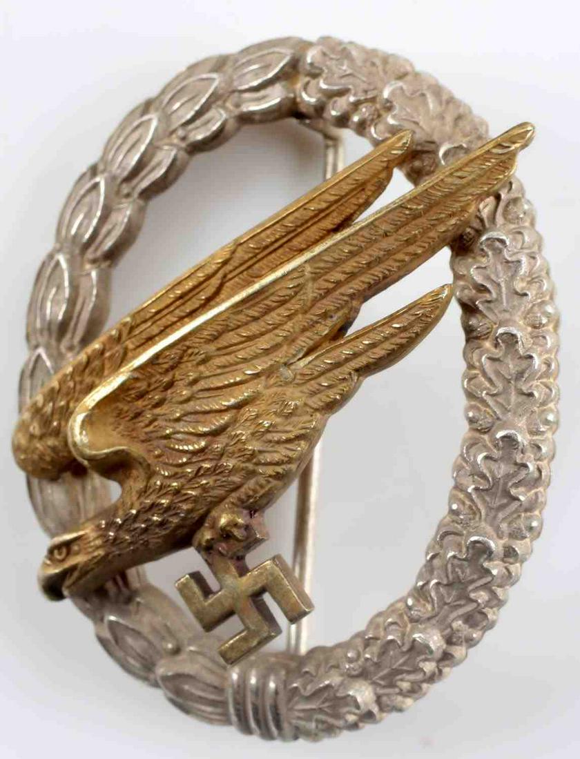 WWII GERMAN FALLSCHIRMJAGER PARATROOPER BADGE: Early Fallschirmjager paratrooper badge. Silvered buntmetal construction rather than zinc with gold toned eagle. 2 piece construction with high domed rivets. Maker marked "C.E. Junker Berlin SW" on re