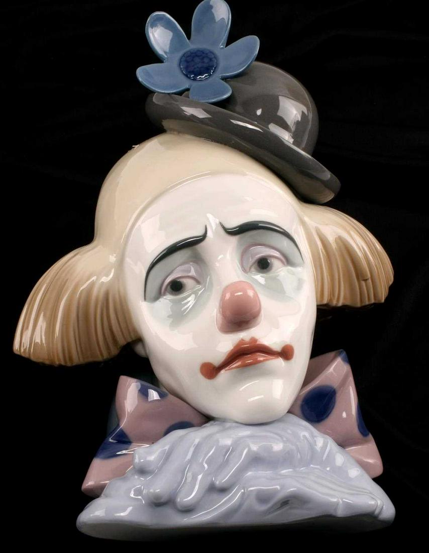 ORIGINAL LLADRO CLOWN HEAD MADE IN SPAIN 5130: Lladro "Pensive Clown" bust, measuring 9.75 inches by 6.75 inches, has a green-grey bowler hat with a blue flower and the blue hands are crossed under chin. The hair is brown and the scarf is pink wit