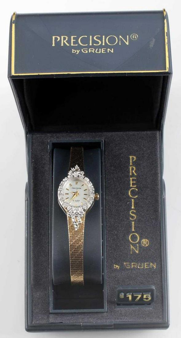 PRECISION BY GRUEN WOMENS WRISTWATCH: Women's Precision watch with accent diamonds around face and gold tone strap. Measures 6.5 inches. In good condition. Needs new battery.