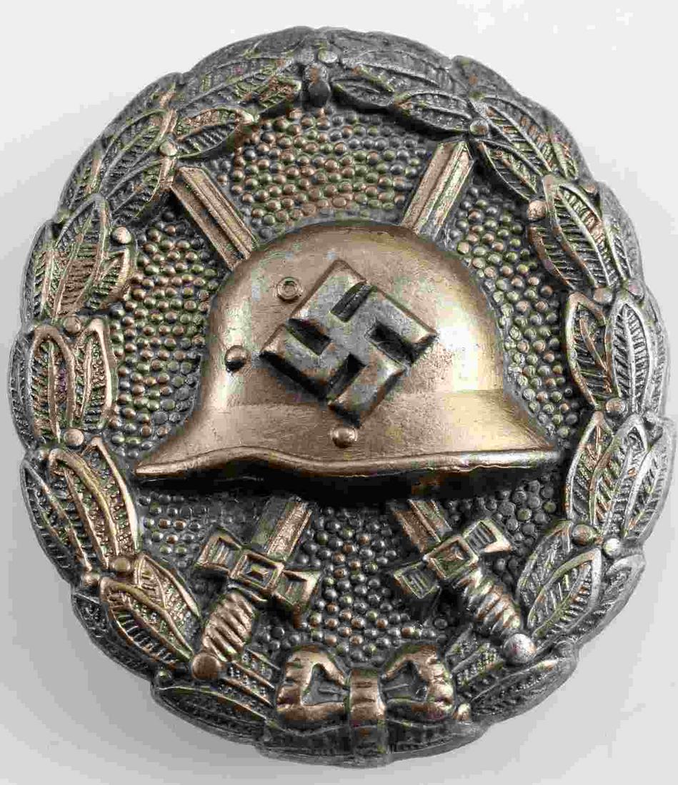 WWII GERMAN SS SILVER CONDOR LEGION WOUND BADGE: WWII German Silver Condor Legion Wound badge in good condition. The front shows a German helemt in the center with a pair of crossed swords in the background. All three are surrounded by an oval oak l
