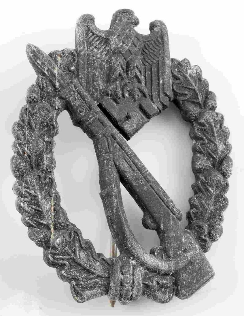 GERMAN WWII ARMY SILVER INFANTRY ASSAULT BADGE: The front has a Mauser K-98 rifle across center with an army eagle above. Measures 2.5 inches across by 1.875 inches. Both surrounded by oak leaf wreath. Thin vertical pin back. The base fittings are 