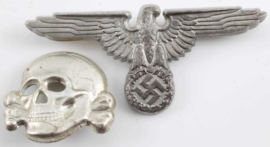GERMAN THIRD REICH SS OFFICERS VISOR EAGLE & SKULL: German WWII Waffen SS Officers Visor Cap Eagle & Skull. They are maker marked ‘RZM M1/21’. Both have two flat horizontal prongs on the reverse side. Stamped silver plated nickel construction. Scar