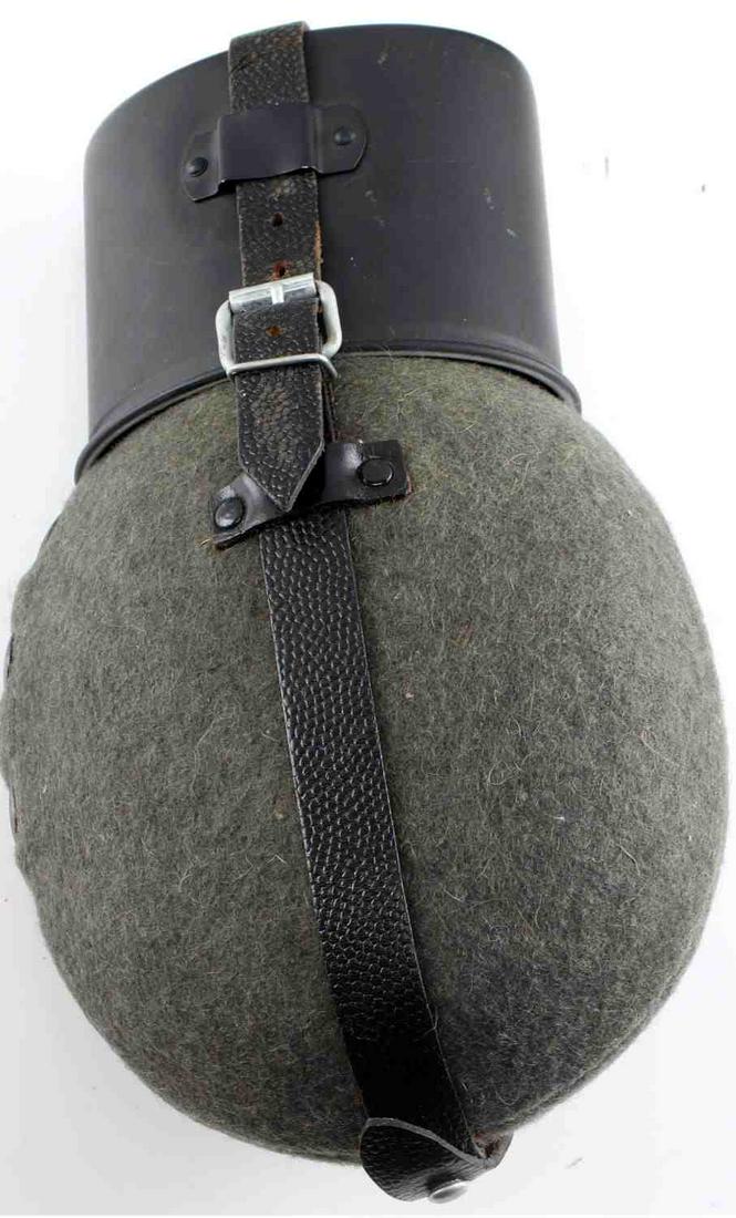 WWII GERMAN ARMY LUFTWAFFE COMBAT FIELD CANTEEN: WWII German Army Luftwaffe Combat Field Canteen. Measures 5 inches wide by 9 inches tall. The aluminum body is covered OD Green wool. Includes the black painted aluminum drinking cup with the black le