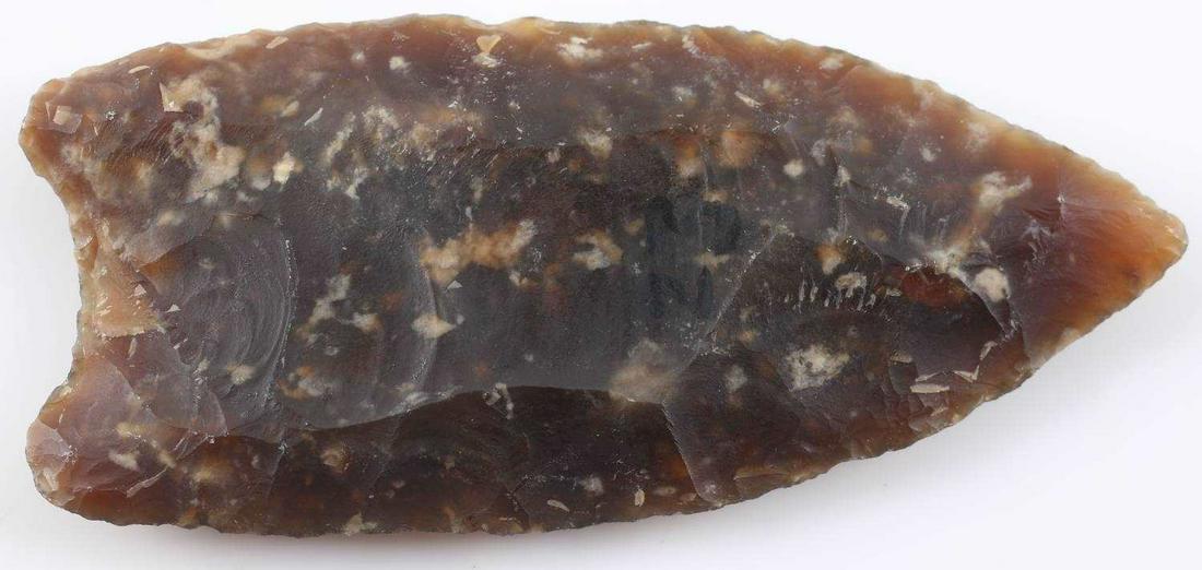 KNIFE RIVER FLINT ARROWHEAD CLOVIS POINT MONTANA: Double fluted with one flute going up one third of the way and the other going up over half, broad and parallel flaking, measures just under 3 inches. Very good condition.